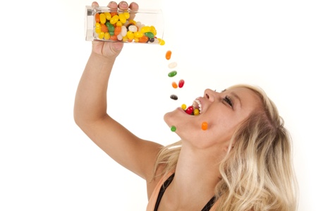 woman pouring jelly beans mouth