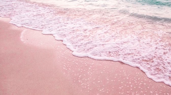 waves washing ashore pink sands beach