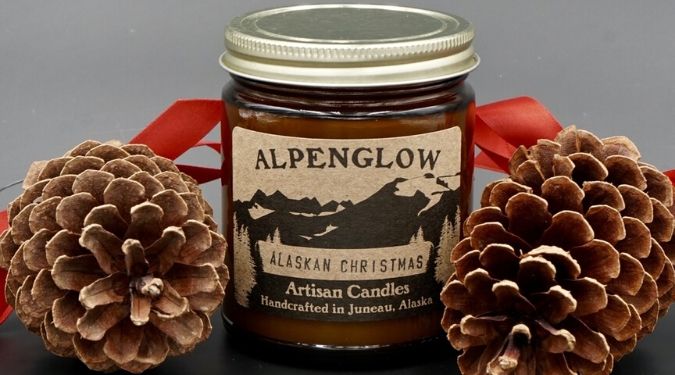 Alpenglow Candle amber jar candle gold lid pine cones red ribbon