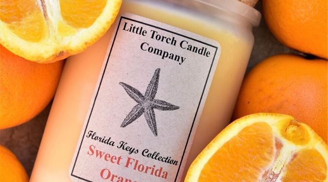 Little Torch Candle Company sweet florida orange soy candle orange wax cork lid among bed of oranges