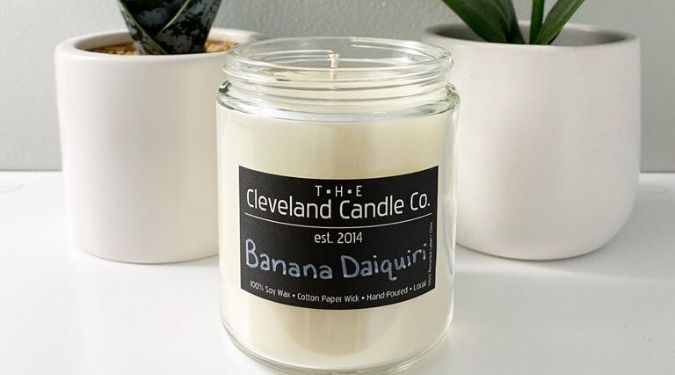 Cleveland Candle Company soy wax candle white wax black label in front of potted plants