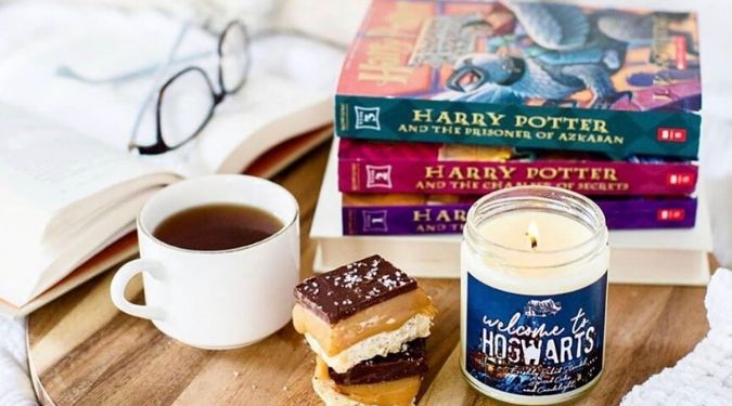 Melting Library soy wax candle on table with books and white mug full of coffee and sea salt caramels