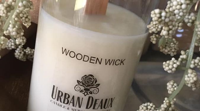 Urban Deaux Candle Company white soy candle with wood wick surrounded by baby's breath