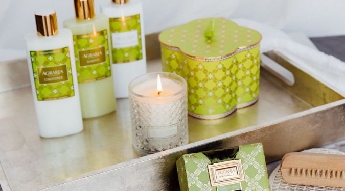Agraria San Francisco candle burning on silver tray with green gift box and bath body products