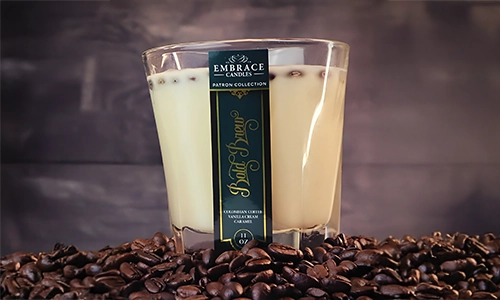 Embrace Candles coffee-inspired candle displayed on a bed of roasted coffee beans