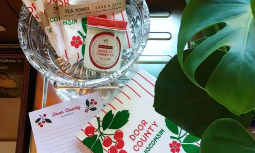 Jack & Joie Door County Cherry Pie Lifestyle Image Jack & Joie Door County Cherry Pie soy candle displayed with Door County themed decor and kitchen linens.