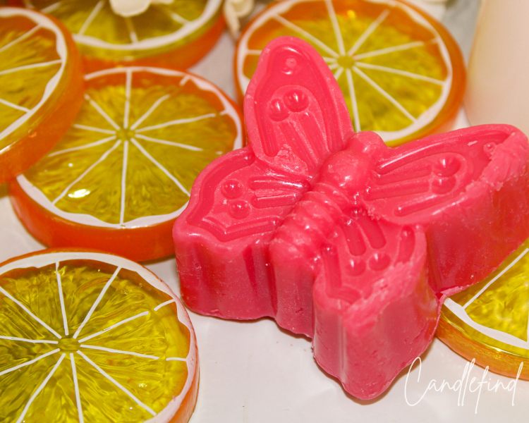 Orange butterfly-shaped Satsuma Lady wax melt from Cheryl's Candles & Gifts displayed on decorative citrus slice wax melts.