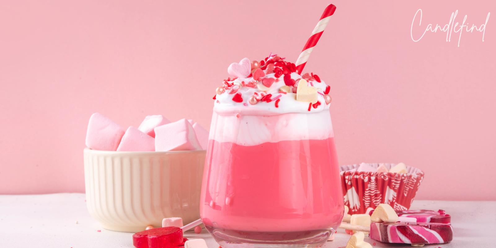 Pink candy-inspired milkshake topped with whipped cream, sprinkles, marshmallows, and heart-shaped candies
